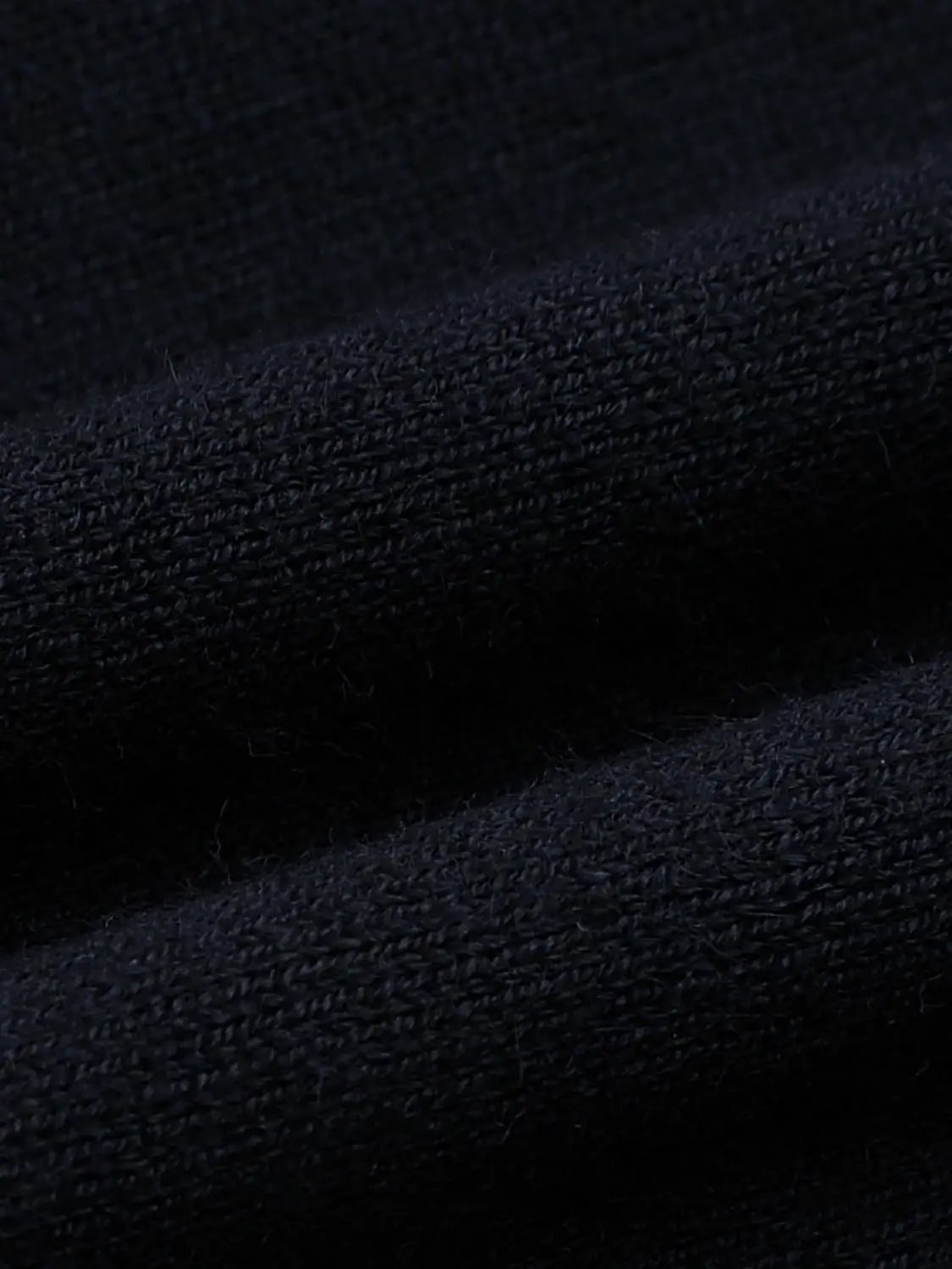 Knitted jacket in dark navy yarn with textured knit fabric.