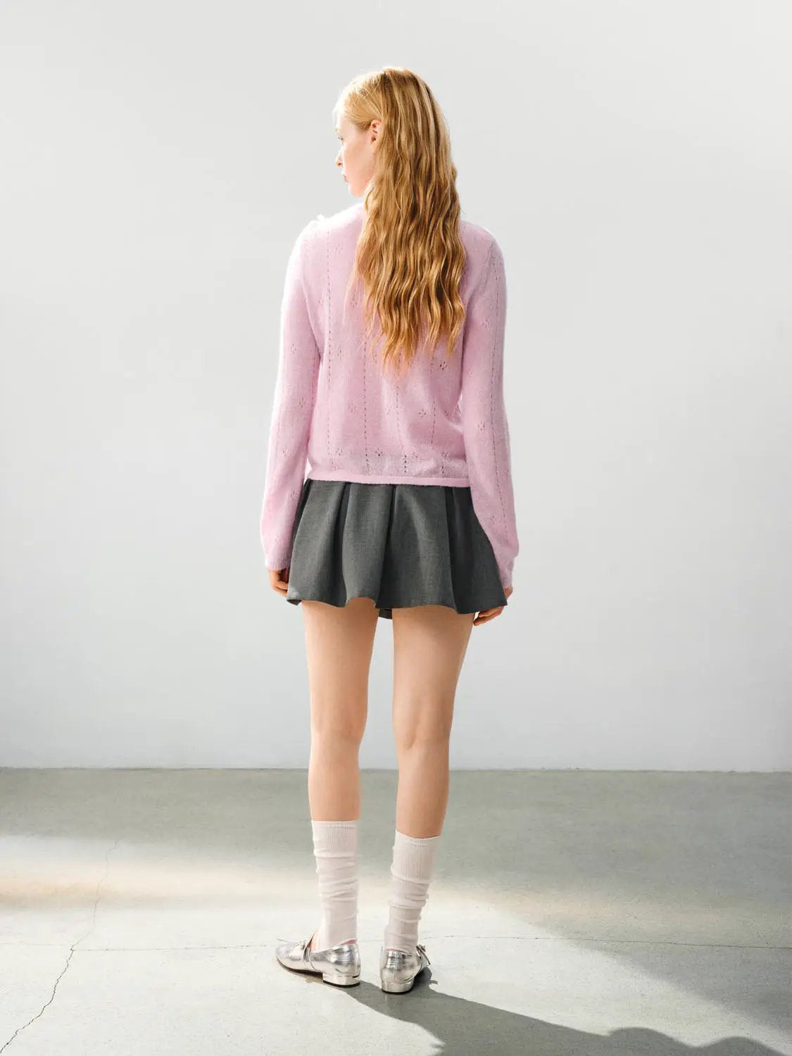 Bow Detail Textured Crew Neck Long Sleeve Sweater in pink knit, paired with a gray pleated skirt