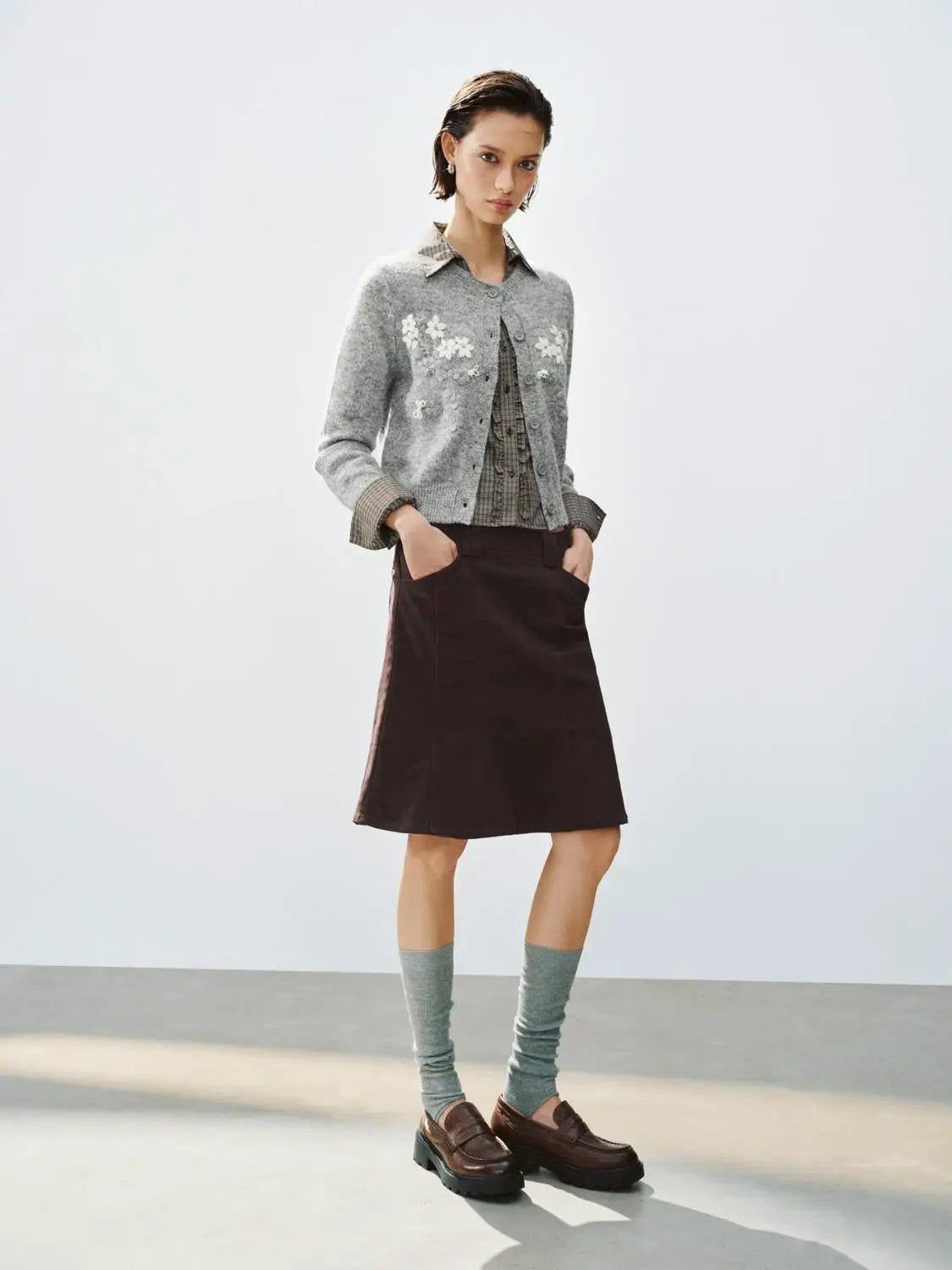 Floral Embroidered Crew Neck Long Sleeve Cardigan, grey knitted with white embroidery, layered over a checkered blouse.