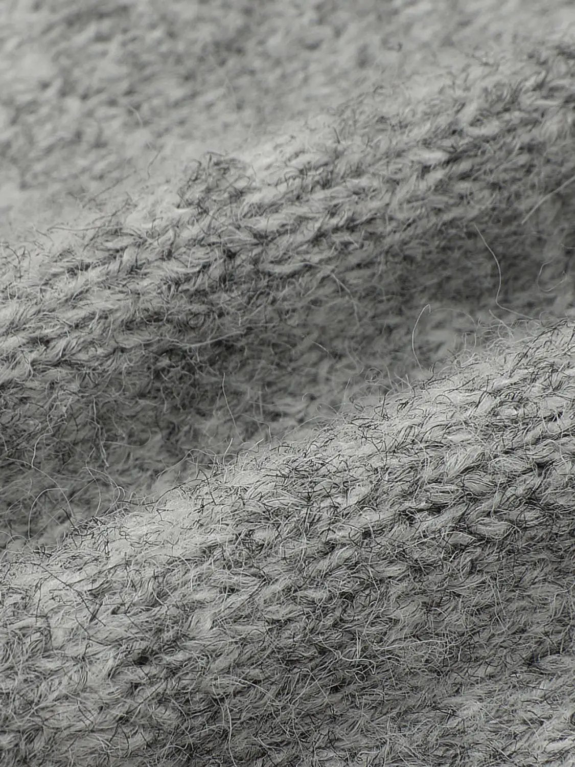 Floral embroidered crew-neck long-sleeve cardigan gray knitted fabric texture with fuzzy fibers close-up.