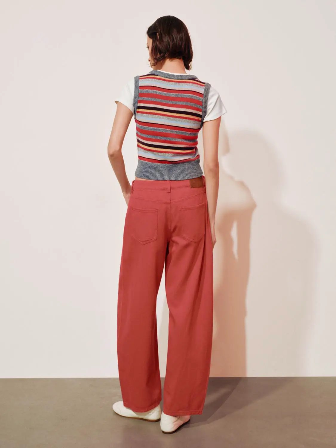 Layered Striped V-neck Knit Short Sleeve T-Shirt worn over white tee; rust wide-leg pants, back view.