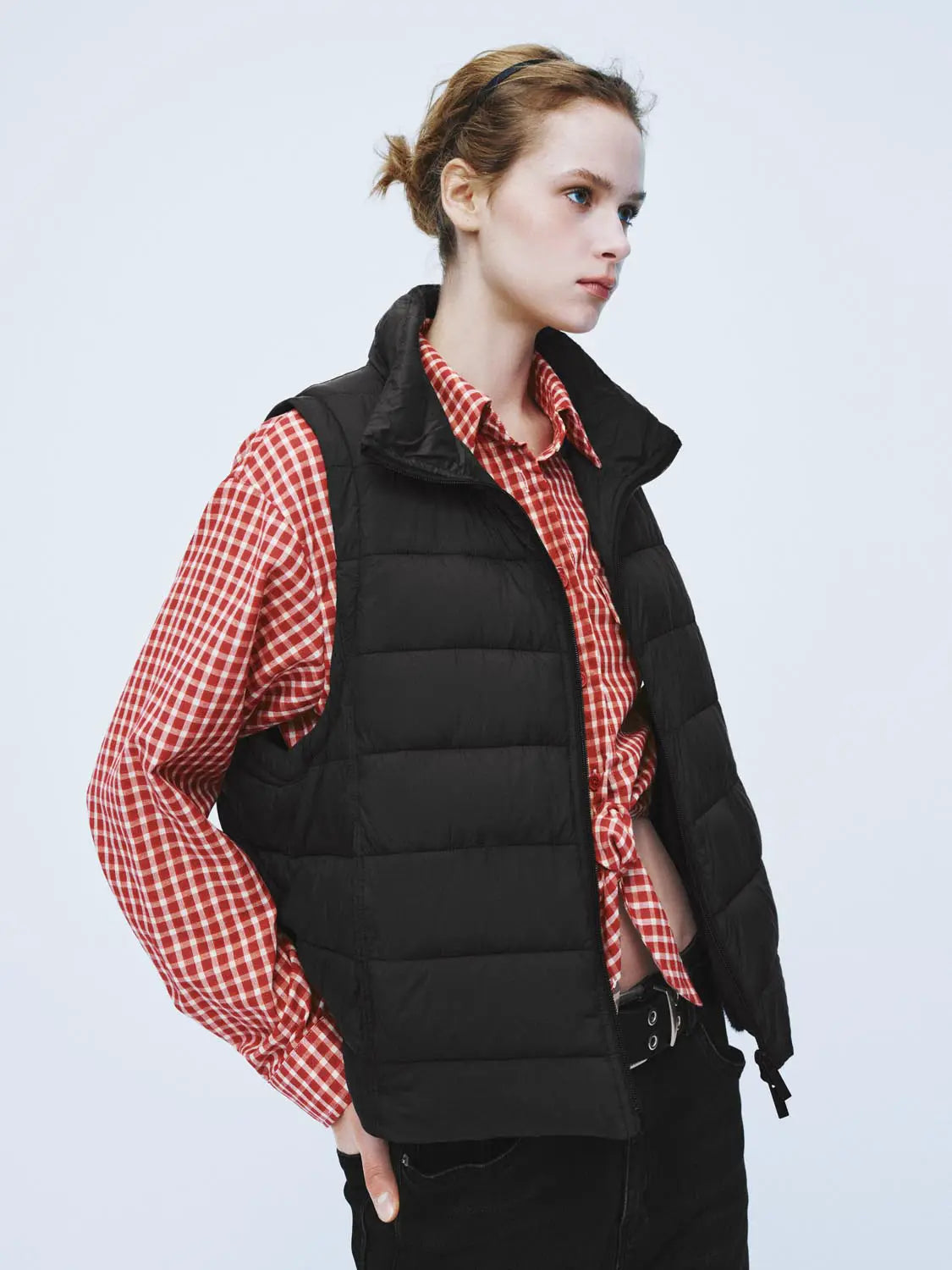 Padded jacket in black, worn over a red gingham shirt by Urban Revivo Fashion.