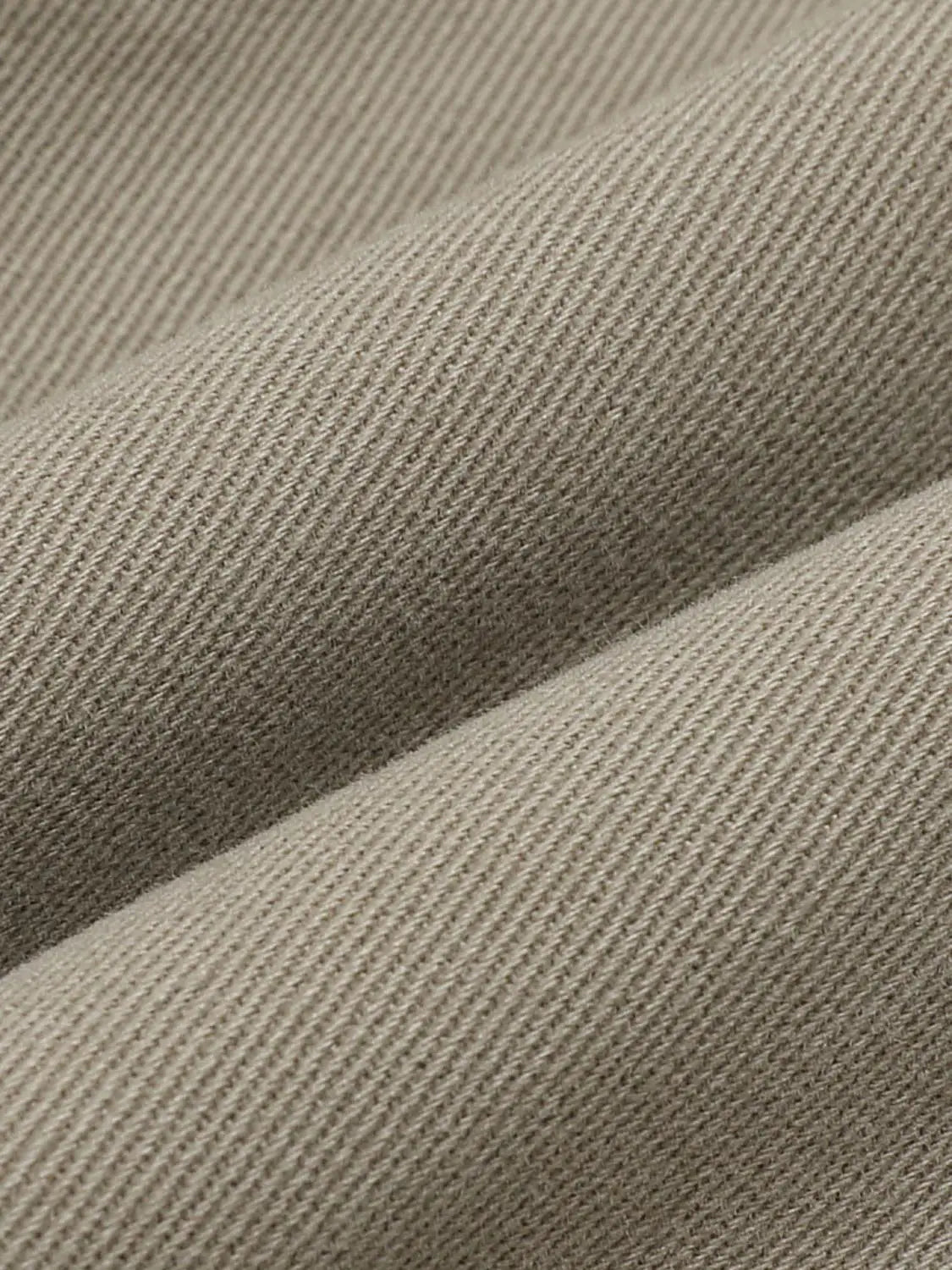 Straight skirt in beige twill fabric; close-up texture.