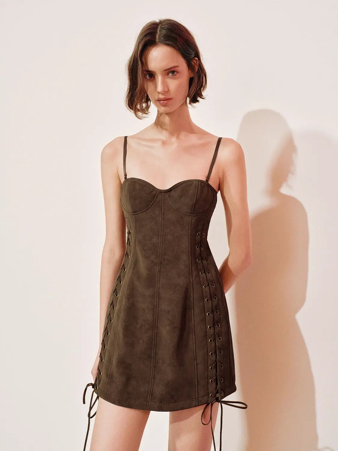Lace-up faux suede corset mini dress in olive-brown with thin spaghetti straps.