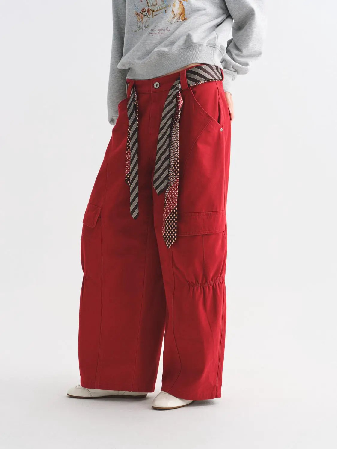 Casual red women's cargo pants with wide legs, side pockets and a striped belt