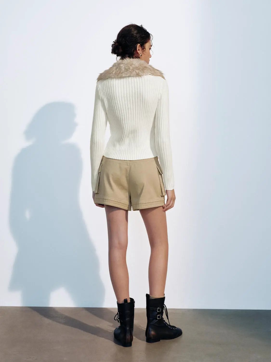 Knit Jacket in white ribbed knit with beige faux fur collar, worn with tan cargo shorts and black lace-up boots
