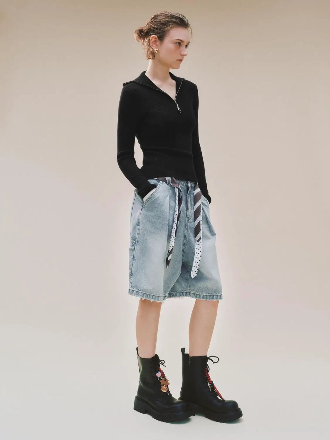 Knitted T-Shirts black zip-neck long-sleeve top paired with light denim knee-length skirt