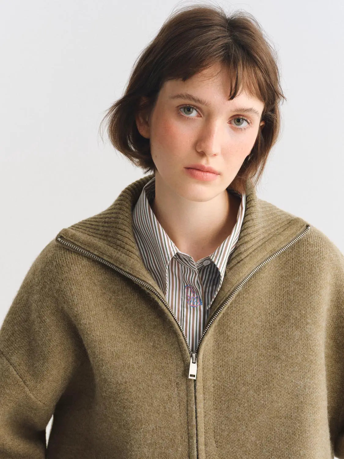 Knit Jacket in camel-brown knit with zip front worn by a model over a striped shirt