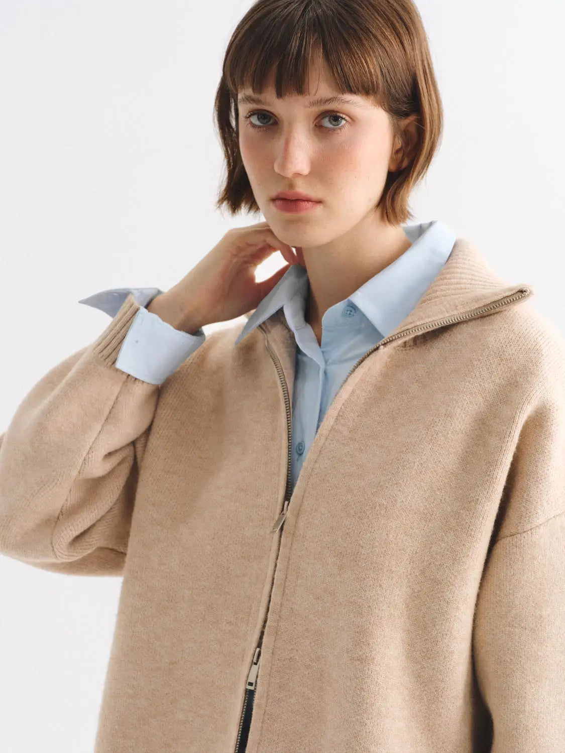 Knit jacket in beige with zip closure over a light blue shirt