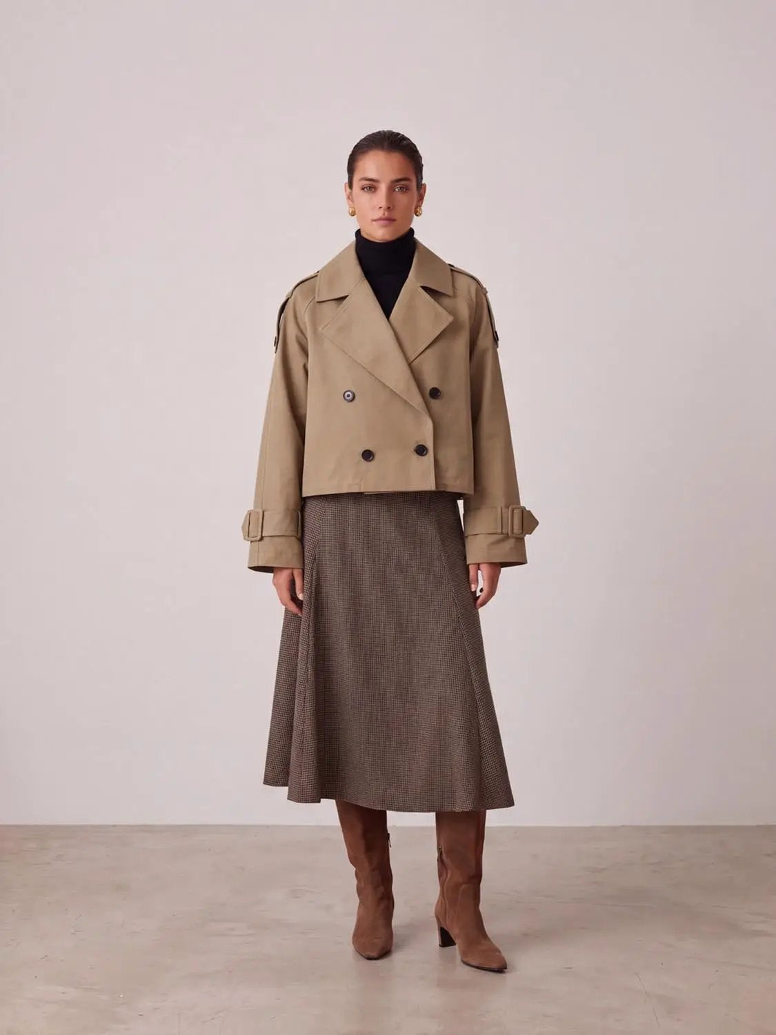 Lapel double-breasted cropped trench jacket in beige with shoulder epaulettes and buckle-tab cuffs.