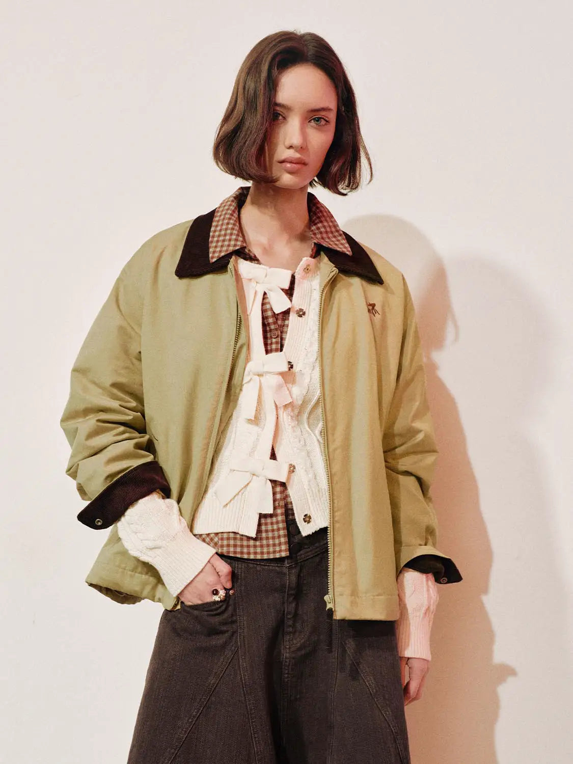 Padded jacket in khaki with a dark brown collar, shown on a model.