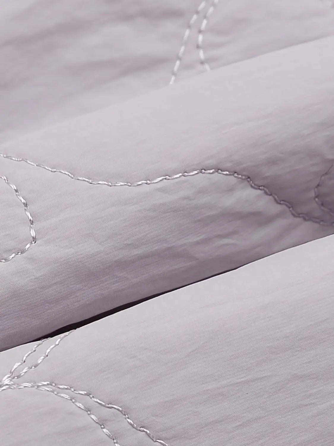 Padded jacket; light gray quilted fabric with visible white stitching.