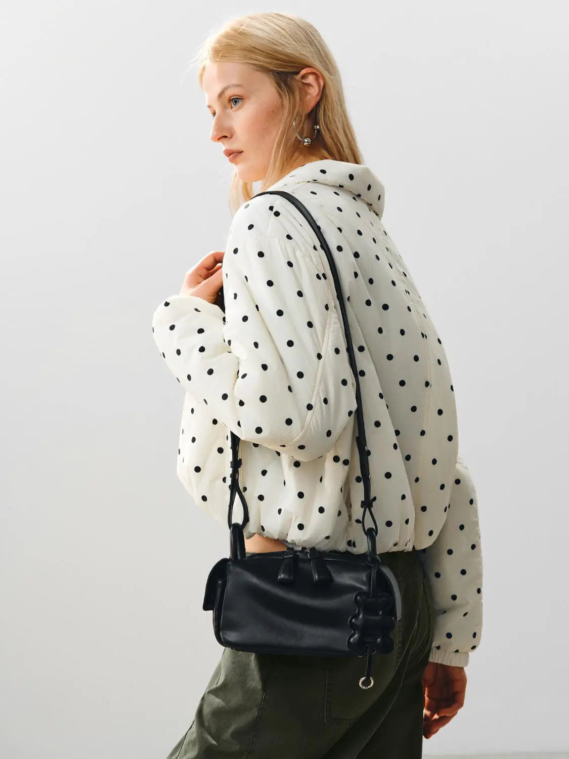 Padded Jacket (UR) in white with black polka dots; model carries a black crossbody bag.
