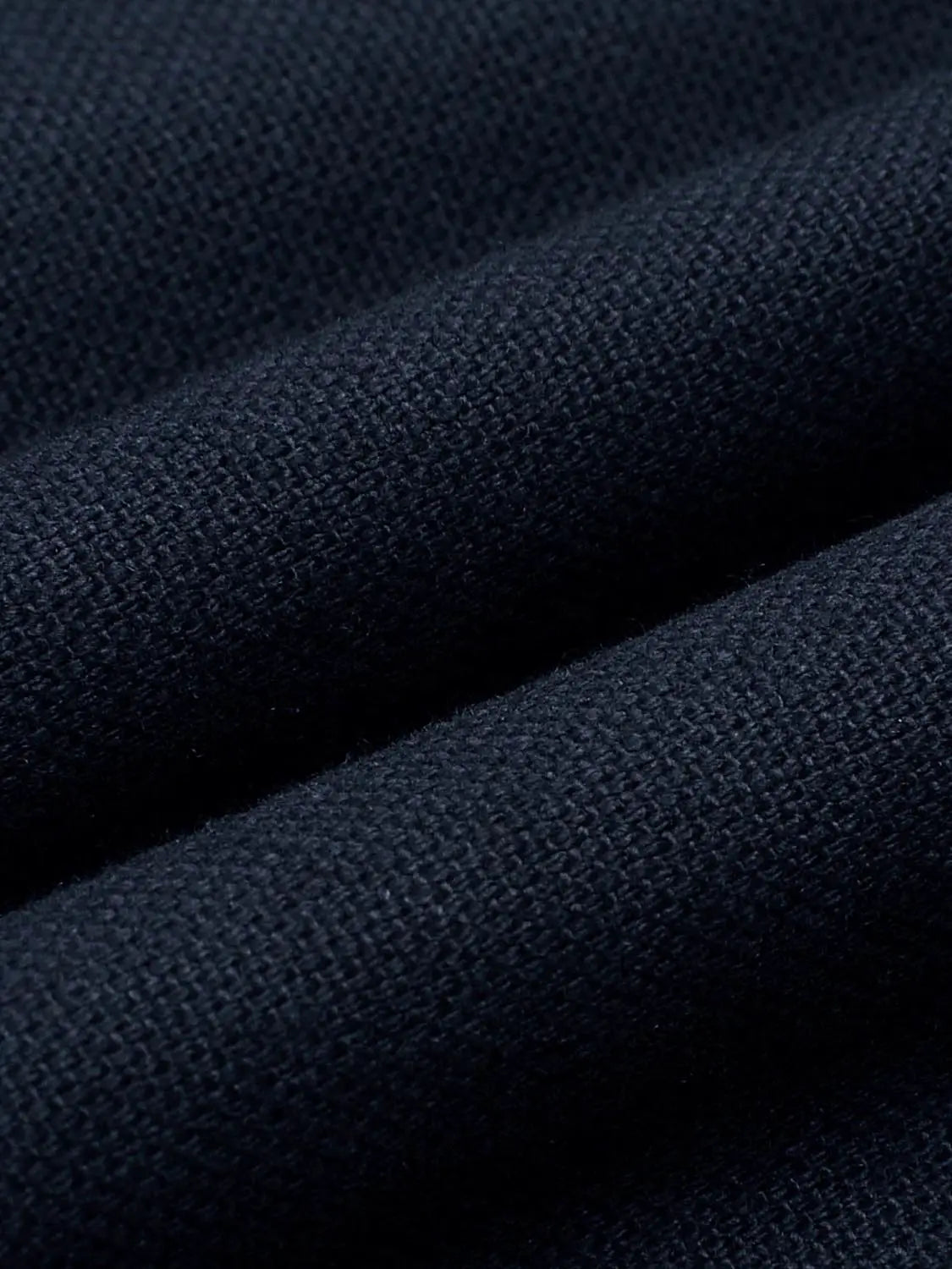 Jacket in navy knit fabric, close-up texture detail.