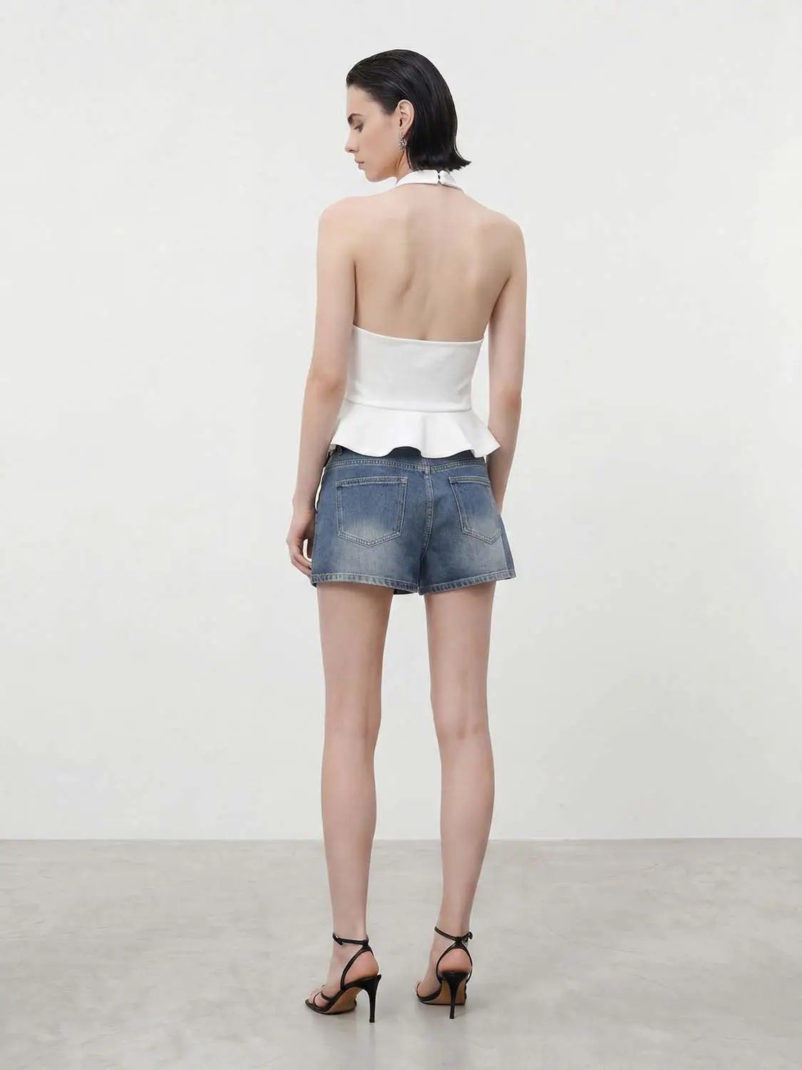 Halter-neck peplum top in white; two-piece outfit with denim shorts visible from back view.