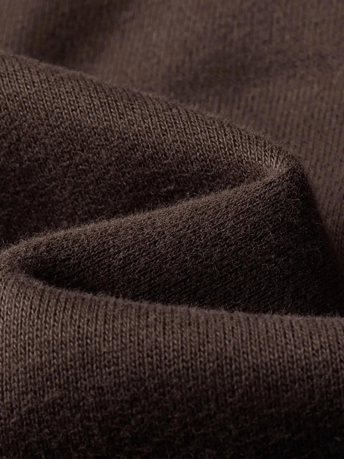 Sweatshirt fabric close-up in brown knit texture, showing soft knit material
