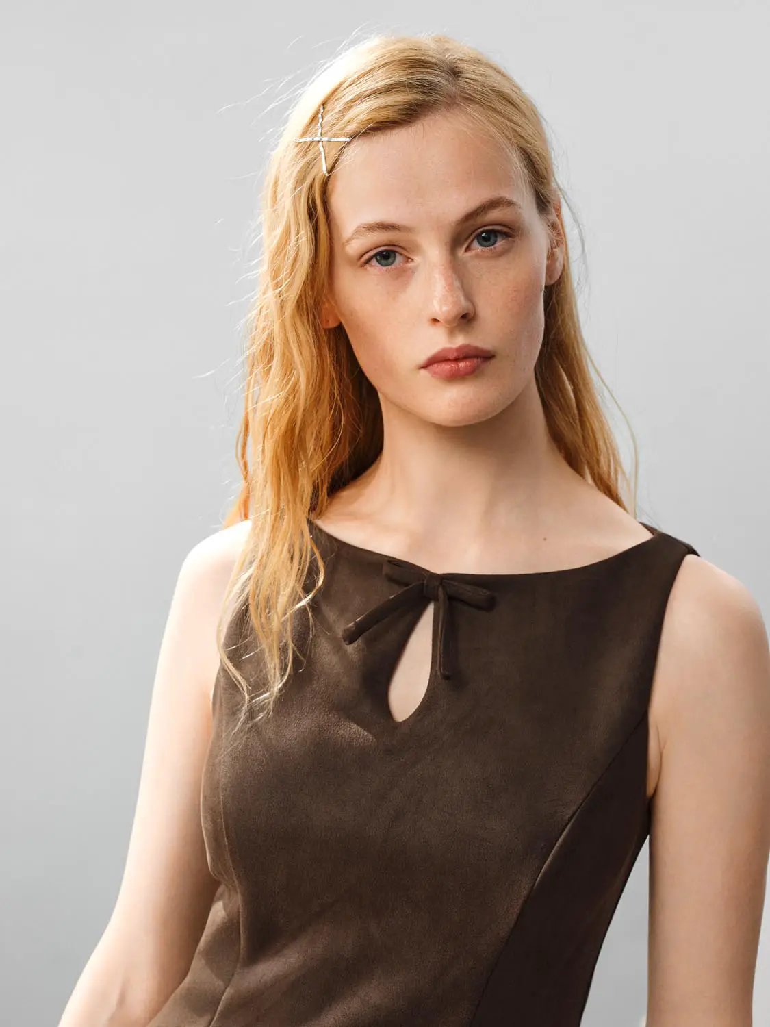 Ruffle Hem Bow Detail Sleeveless A-Line Mini Dress in brown satin with front bow accent.