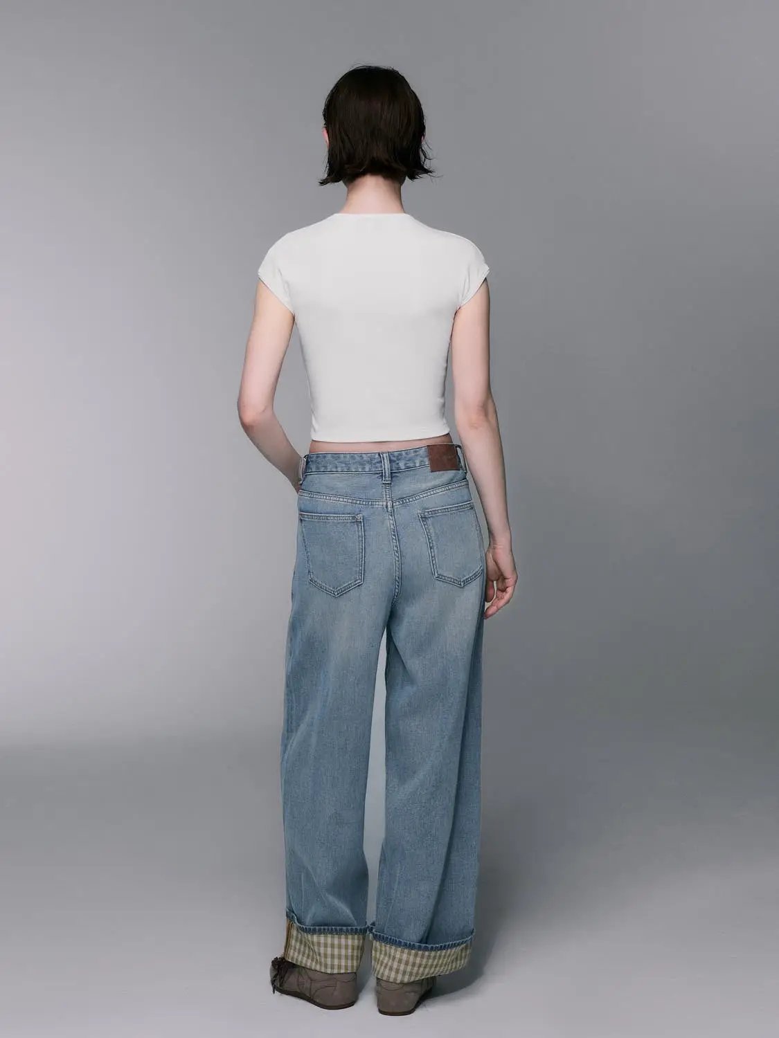 Light-wash cotton-lyocell wide-leg jeans, back view with cuffed hems.