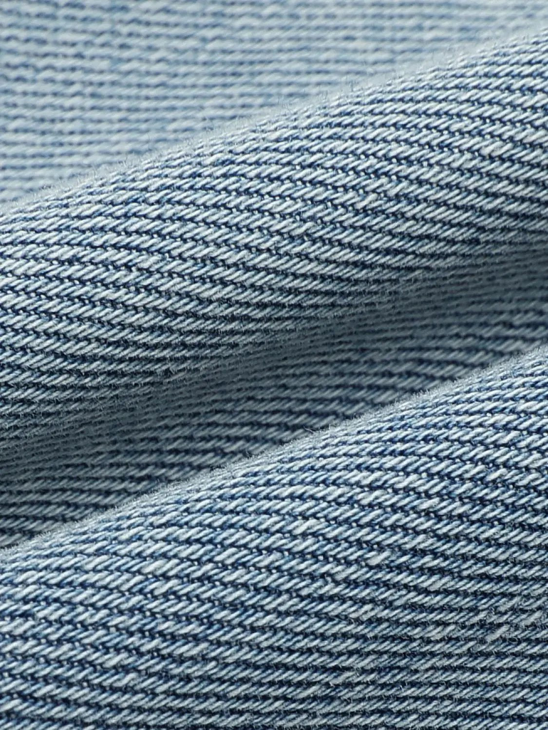 Light wash wide-leg cotton lyocell blend jeans fabric close-up showing denim texture
