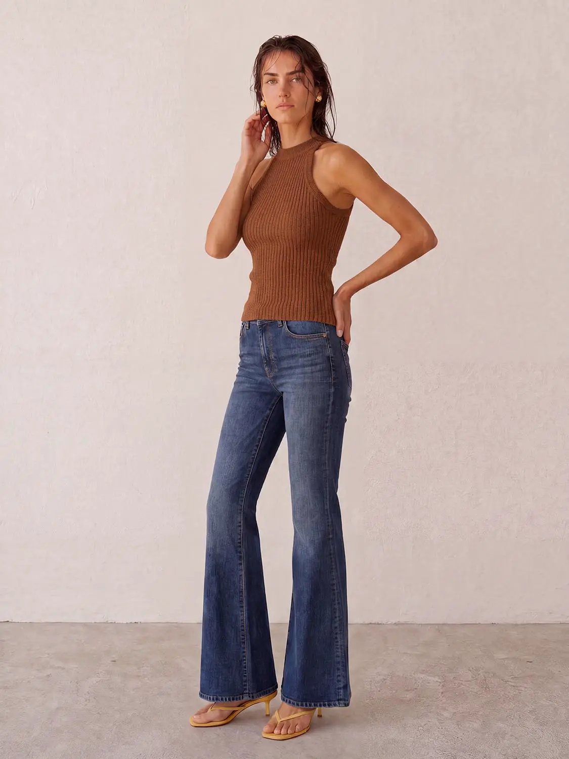 Knitted vest in brown rib-knit; sleeveless top paired with blue jeans