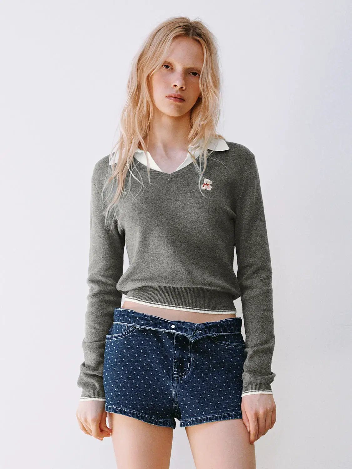 Knit T-Shirt, gray knit top with white collar peeking out, small chest embroidery; blue polka-dot denim shorts.