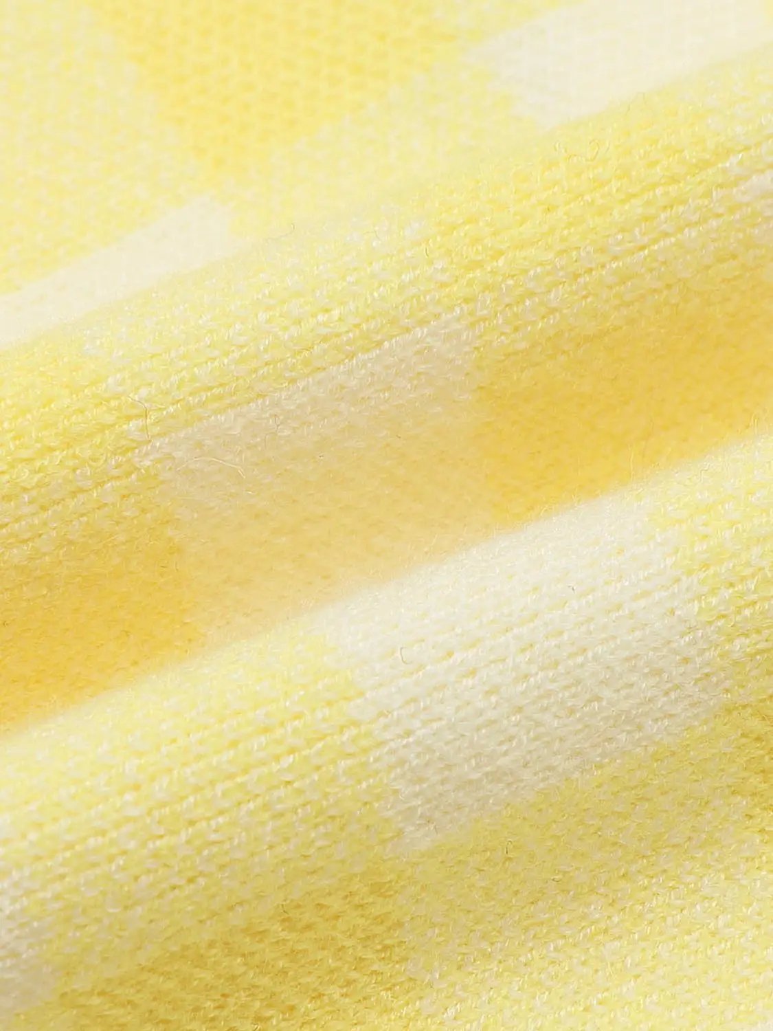Knitted cardigan fabric in yellow stripes; soft textured knit close-up