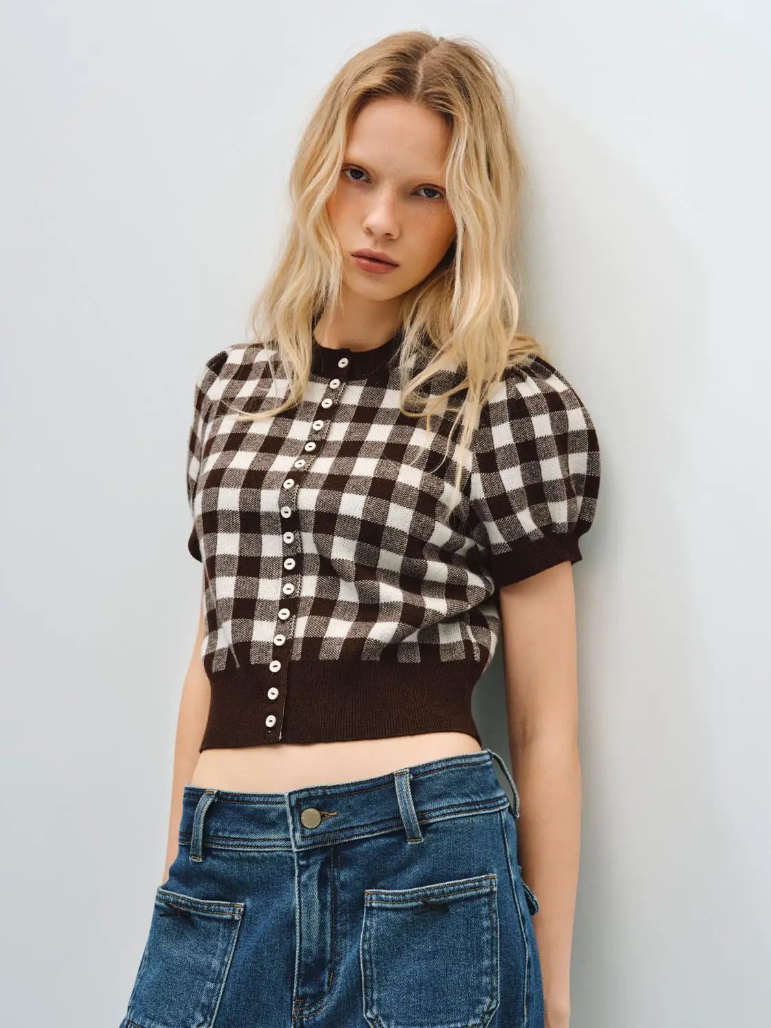 Knitted cardigan in brown and cream gingham with button-front, cropped hem, puff sleeves.
