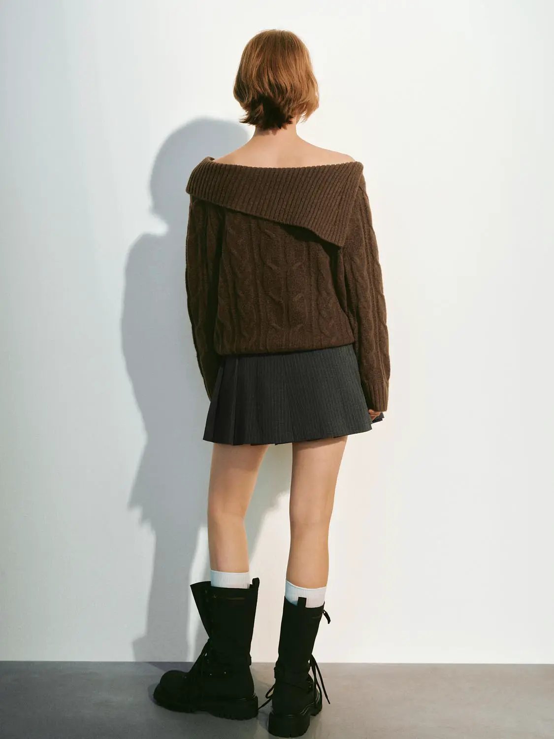 Knitted T-Shirts, 2-piece brown oversized knitted top with off-shoulder neckline; black pleated mini skirt