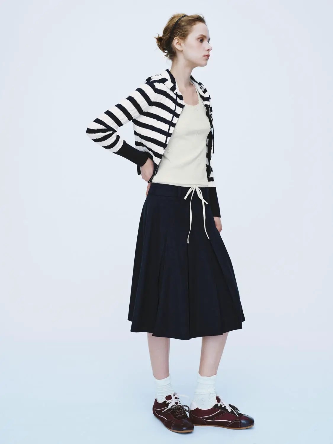 Knit cardigan in black-and-white stripes by Urban Revivo Fashion, paired with cream top and navy drawstring skirt.