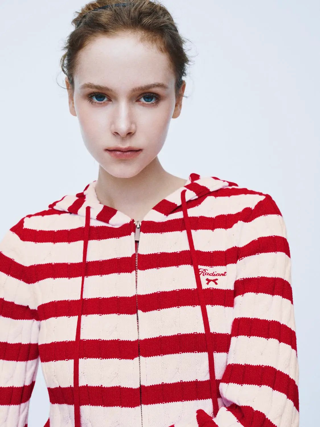 Knitted cardigan hoodie with red and cream horizontal stripes and a front zipper.