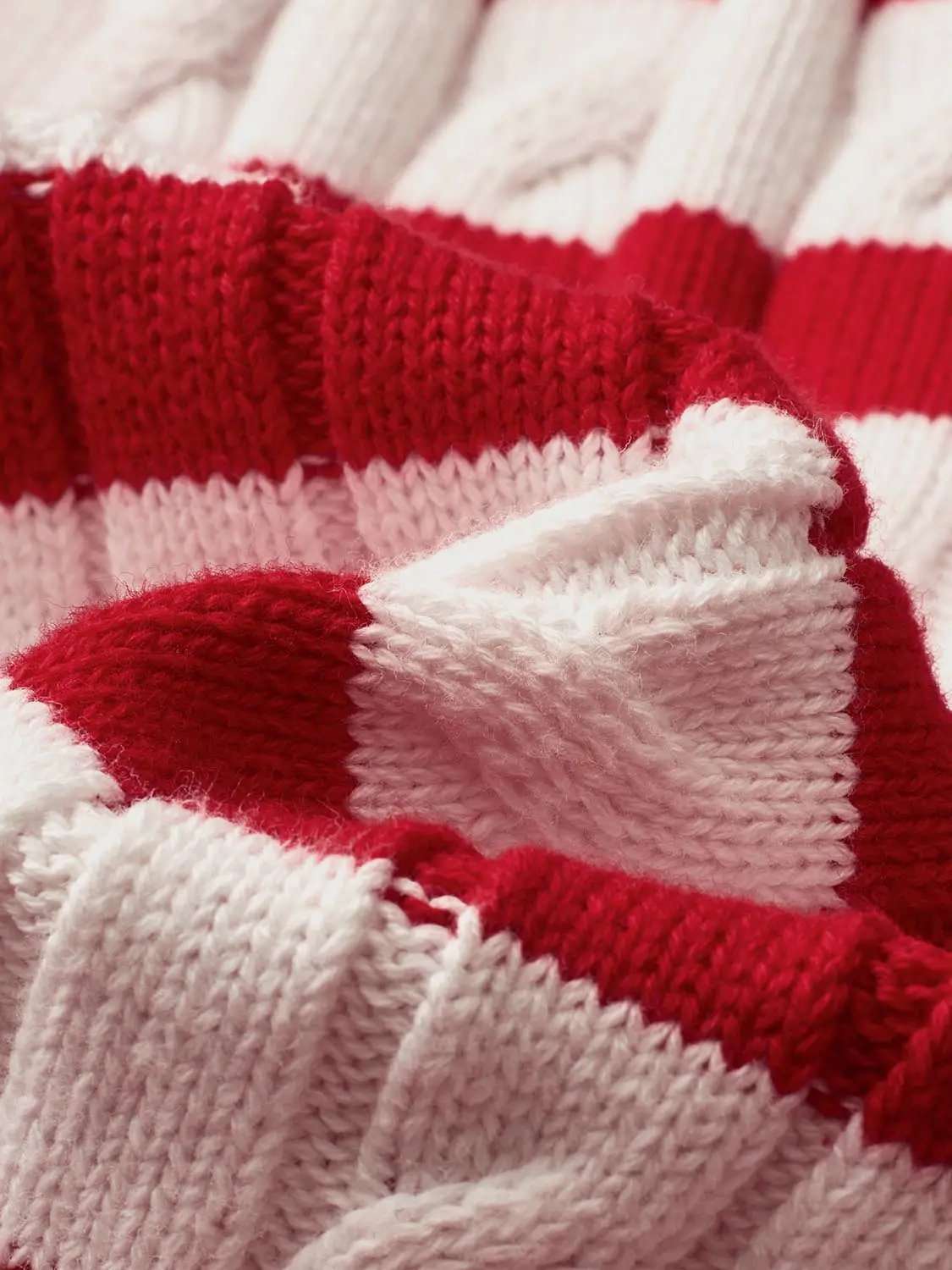 Knitted cardigan by Urban Revivo Fashion in red and pink stripes, close-up of knitted fabric.