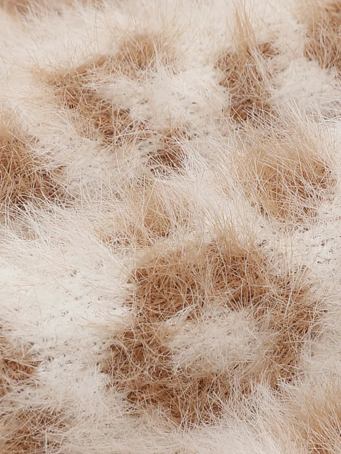 Knit jacket in beige fluffy yarn texture, close-up view.